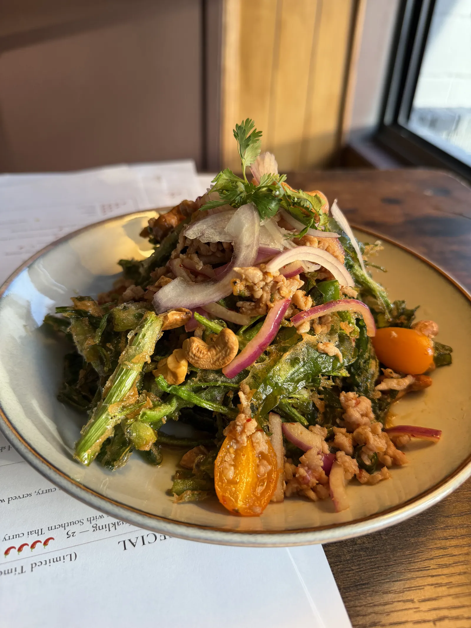 Crispy morning glory salad with ground pork, cherry tomatoes, cashews and shallots