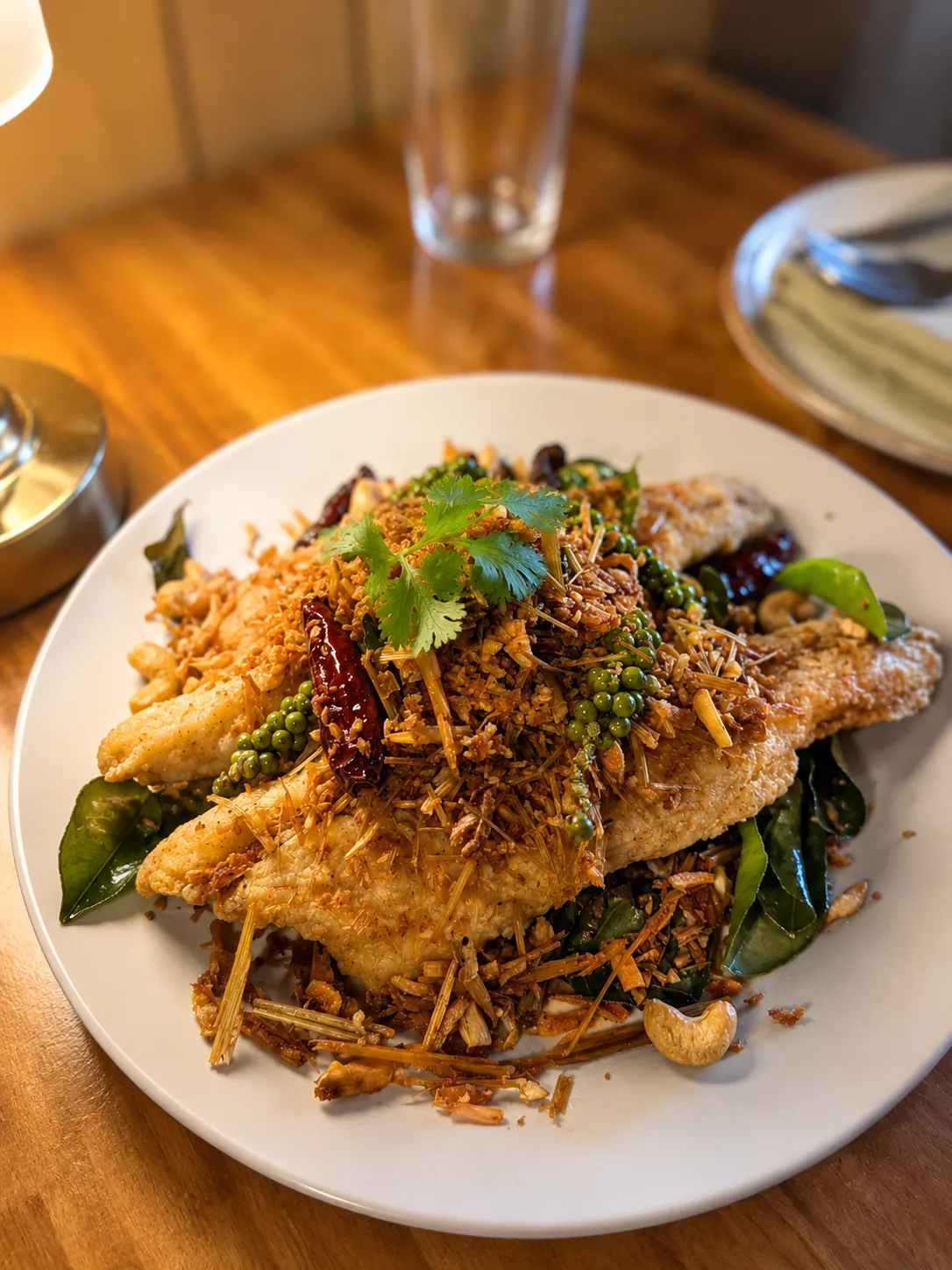 Crispy fish fillet topped with fried herbs and chilies